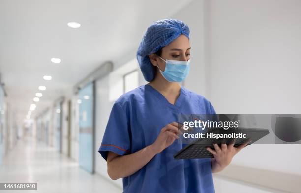 arzt, der während der arbeit im krankenhaus ein tablet benutzt - frontline worker stock-fotos und bilder