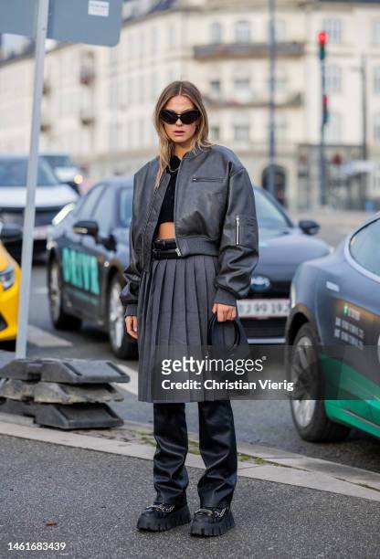 Alessa Winter wears grey leather jacket, high waisted pleated skirt, black leather pants, Coperni bag, platfrom shoes, cropped black to outside...