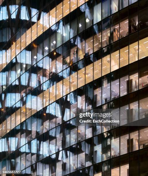 reflections in glass office facade at dusk - european banking headquaters photos et images de collection
