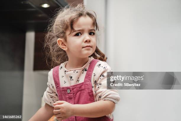 portrait of a girl with serious gesture in the kitchen - tegendraads stockfoto's en -beelden