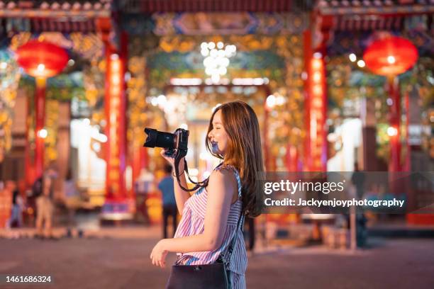 low angle view of beautiful young asian woman photographing lantern decoration for chinese new year in chinatown. - thailand illumination festival bildbanksfoton och bilder