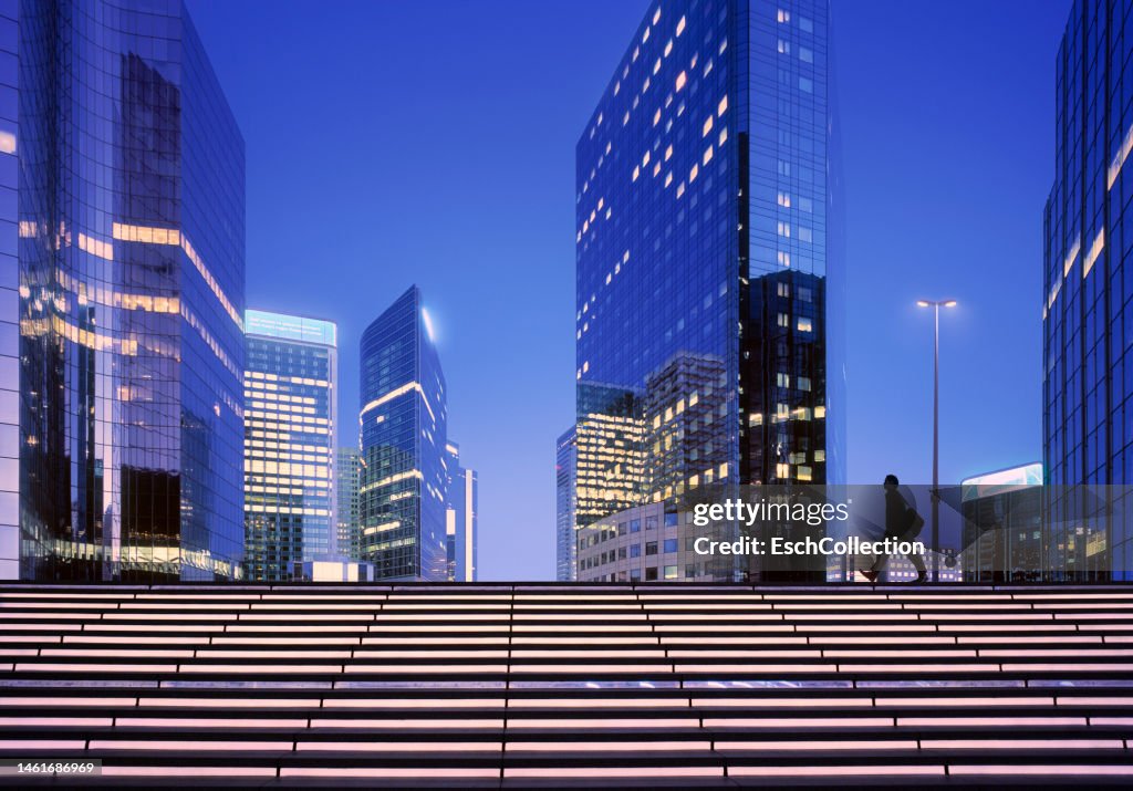 Businessman arriving at modern business district at dawn
