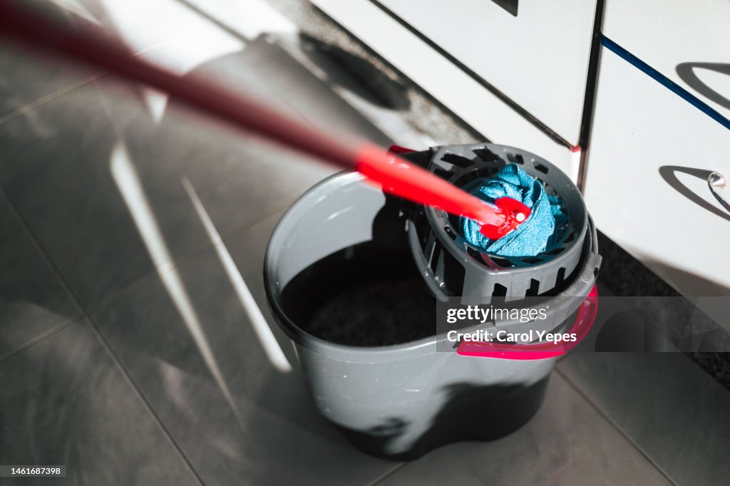 Close-up of mop and cleaning bucket on the kitchen,Casting shadows