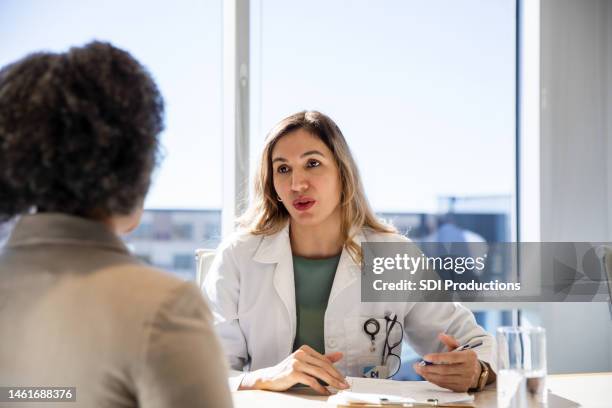 female doctor gives female patient bad news - bad job interview stockfoto's en -beelden