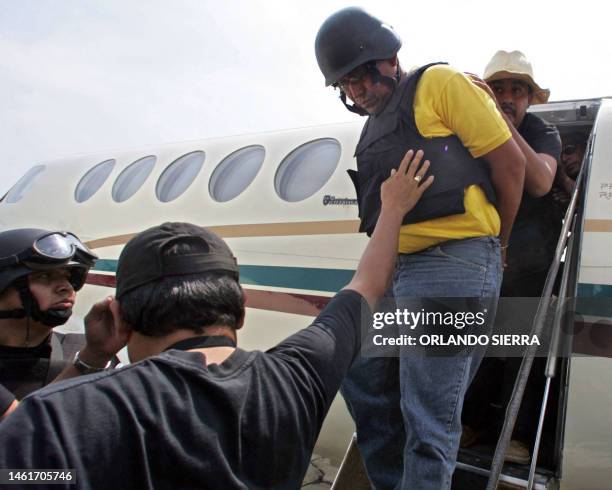Agentes de la Policia Nacional Civil ayudan a bajar de un avión a Wagner Amilcar Morales Silva , supuesto implicado en la muerte de los tres...