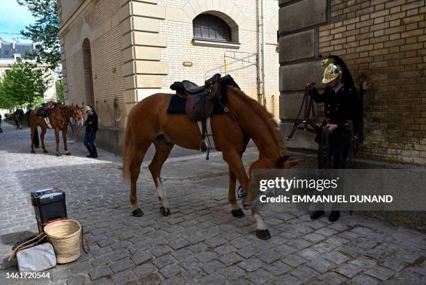 French Republican Guard cavalry officer remove the bridles from his horse after taking part in a reahearsal for a French national day parade, at the...