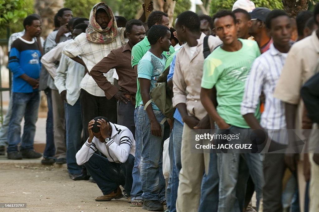 African migrants line up to receive a fr