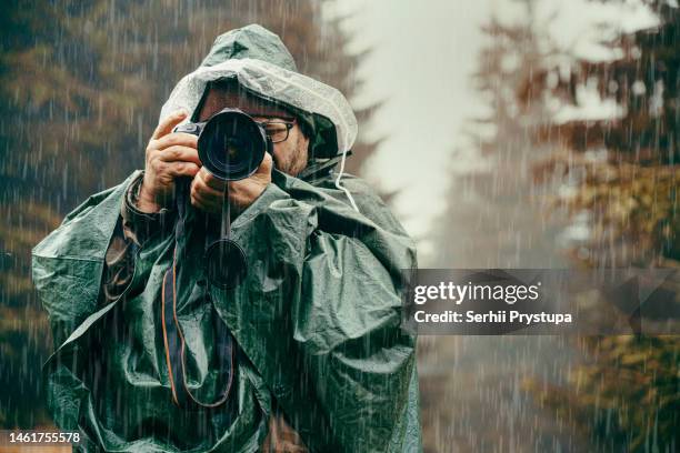 photographer in the rain - travel photographer stock pictures, royalty-free photos & images