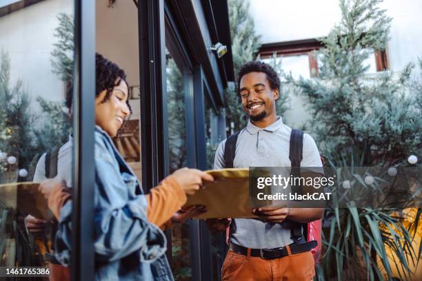 courier delivers the parcel to a customer at her home - courier envelope stock pictures, royalty-free photos & images