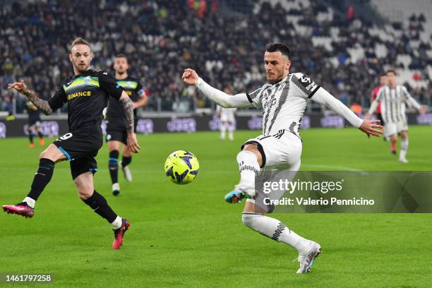 Filip Kostic of Juventus shoots under pressure from Manuel Lazzari of SS Lazio during the Coppa Italia Quarter Final match between Juventus FC and SS...