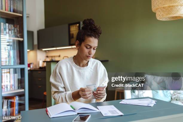 worried young woman taking care of personal finances - problem stock pictures, royalty-free photos & images