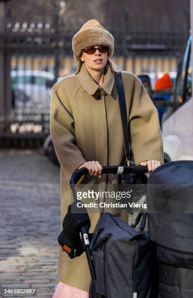 Hanna Stefansson with baby buwears brown beanie, coat outside Helmstedt during the Copenhagen Fashion Week Autumn/Winter 2023 on February 02, 2023 in...