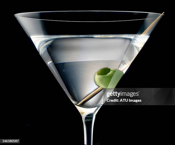 a martini with an olive - vodka stock-fotos und bilder