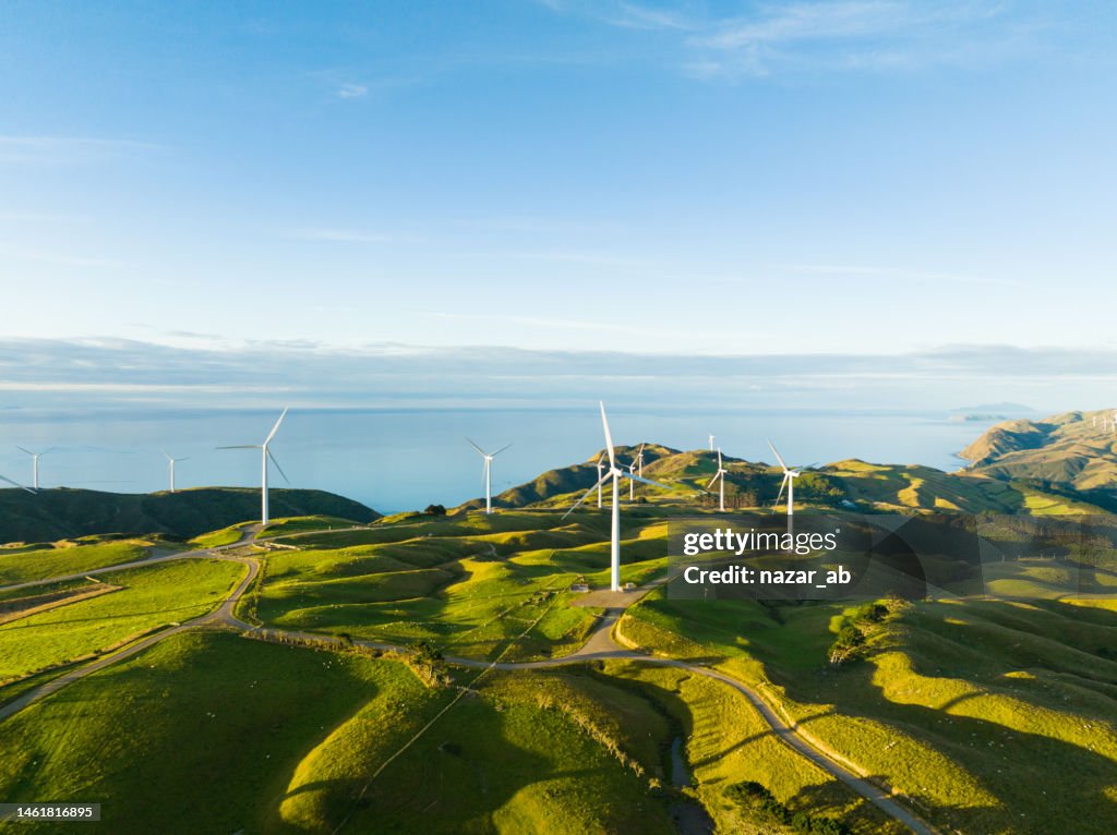 Ansicht von oben auf Windmühlen mit Küste im Hintergrund.