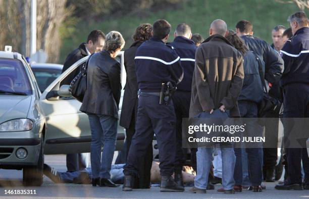 Policemen and Gendarmes look at the body of a French mobster who was killed in a drive-by shooting in Bouc-Bel-Air near the Mediterranean port of...