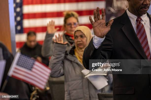 Immigrants take the oath of allegiance to the United States during a naturalization ceremony on February 01, 2023 in Newark, New Jersey. Thirty-five...