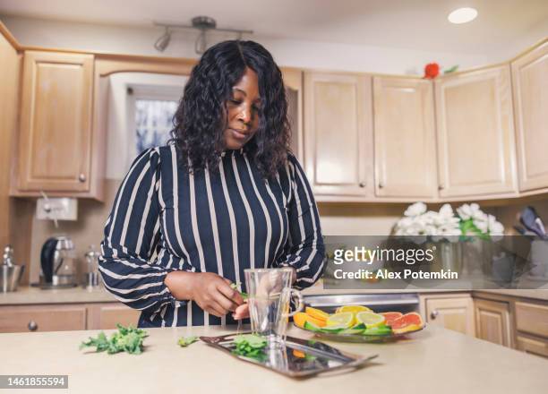 la tisana viene preparata nella sua cucina da un'attraente donna afroamericana nera. - "alex potemkin" or "krakozawr" foto e immagini stock