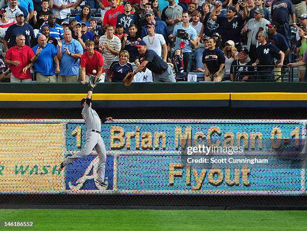 Nick Swisher of the New York Yankees makes a catch to rob Brian McCann of the Atlanta Brave of a home run at Turner Field on June 11, 2012 in...