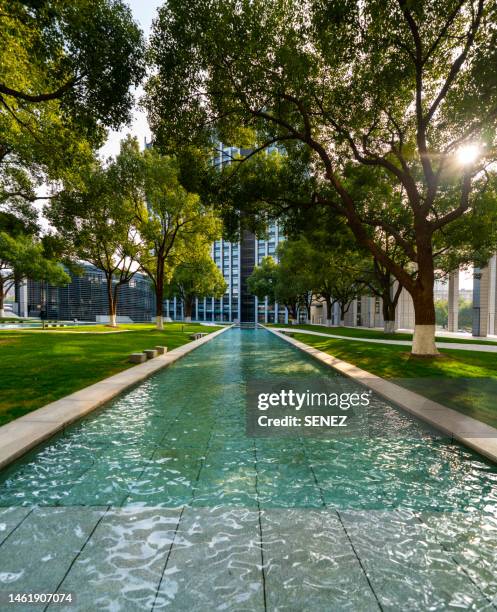 artificial pool in park of financial district - piscina riflettente foto e immagini stock