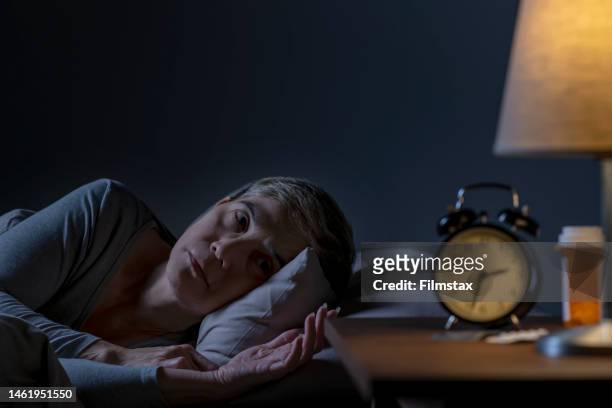 depressive seniorin, die im bett liegt, kann nicht vor schlaflosigkeit schlafen - can't sleep stock-fotos und bilder