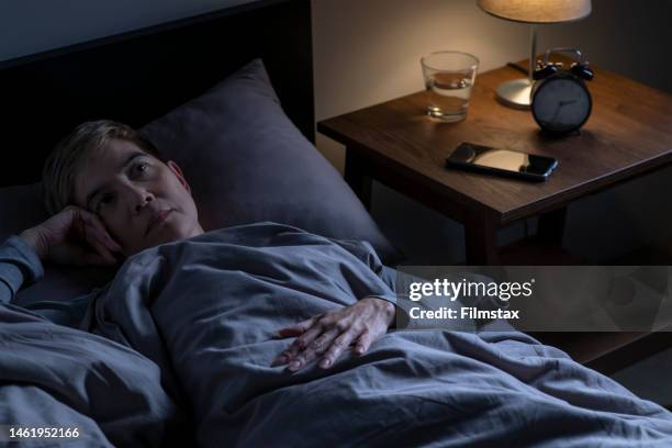 depressed senior woman lying in bed cannot sleep from insomnia - awake stock pictures, royalty-free photos & images