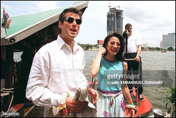 Irish actor Pierce Brosnan and Malaysian-born Hong Kong star Michelle Yeoh disembark from a boat on Bangkok's Chao Phraya river 15 May on their way...