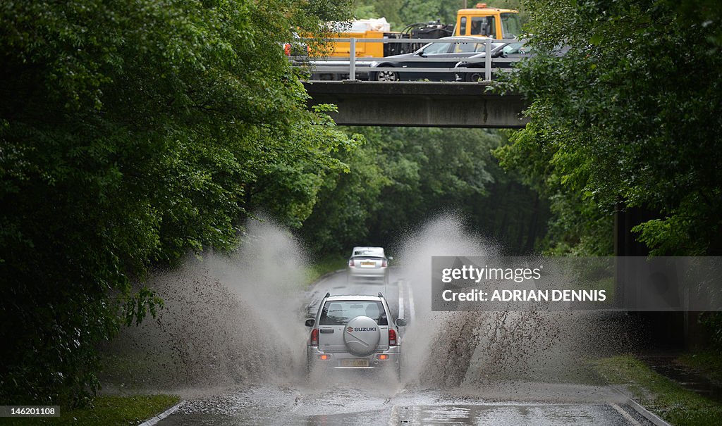 A car drives through a large puddle on a