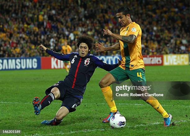 Tim Cahill of Australia is challenged by during the FIFA World Cup Asian Qualifier match between the Australian Socceroos and Japan at Suncorp...