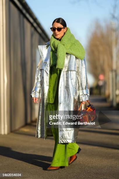 Julia Haghjoo wears brown print pattern sunglasses, a green embroidered wool pullover knot at the shoulder, a green ribbed velvet blazer jacket,...