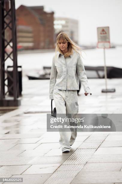 Jeanette Madsen wearing light washed out blue wide jeans, matching denim jacket, and black triangle Prada bag outside A. Roege Hove, during the...