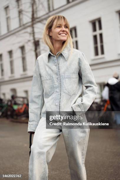 Jeanette Madsen wearing light washed out blue wide jeans, matching denim jacket, and black triangle Prada bag outside A. Roege Hove, during the...