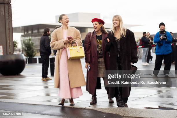 Marianne Theodorsen wearing a pale pink wool maxi skirt and matching sweater, a beige long coat, a pale pink and yellow shiny leather handbag, and...