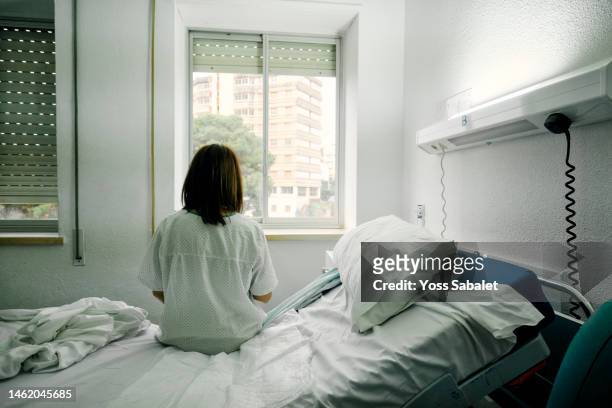 sick woman alone in a hospital room - illness hospital stock pictures, royalty-free photos & images
