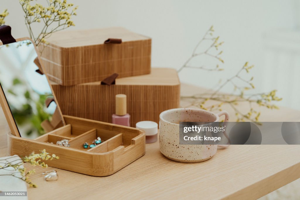 Bodegón moderno en casa joyero en maquillaje de madera y copa de café