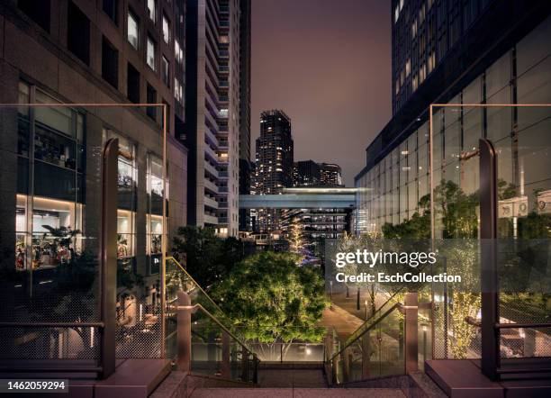 people mover (motion blurred) passing through modern business and residential district of tokyo - bridge building glass stock pictures, royalty-free photos & images