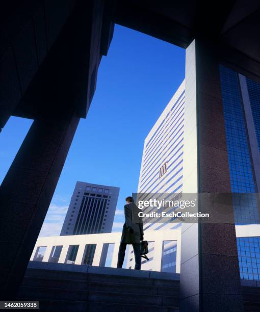 businessman walking to work in a modern office park at dawn - chasing perfection stock pictures, royalty-free photos & images