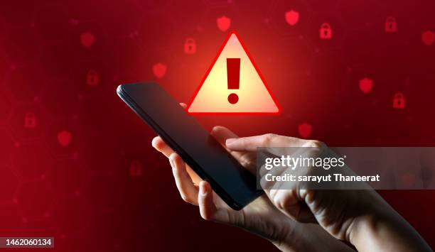 hacker in hoodie dark theme hacker in a blue hoody standing in front of a coding background with binary streams and information security terms cybersecurity concept - computervirus stock-fotos und bilder