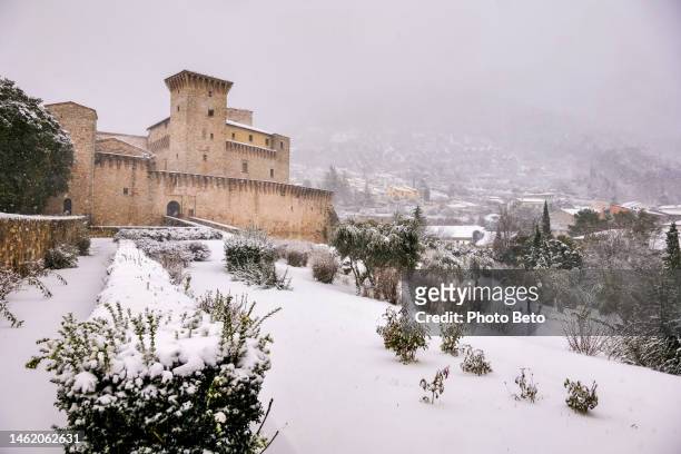 a beautiful winter scene in a medieval small town in umbria in central italy with a castle and snow-covered streets - mountain village stock pictures, royalty-free photos & images