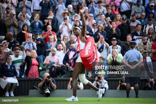 Player Venus Williams waves to the audience as she leaves the court following her defeat against Ukraine's Elina Svitolina at the end of their...