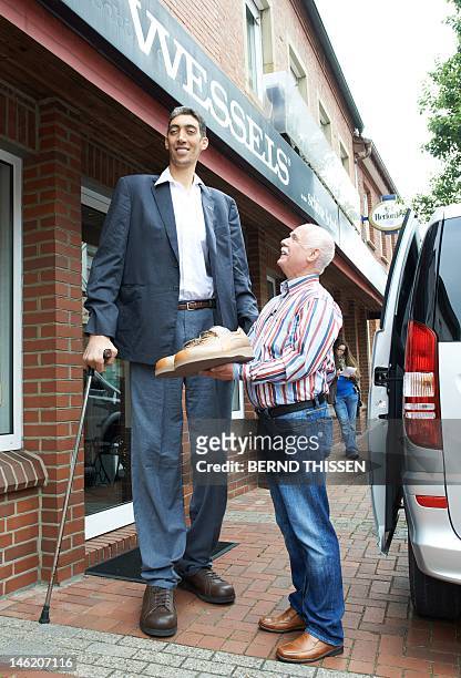 Shoemaker Georg Wessels and Turkish Sultan Kosen, the Guinness World Record holder for tallest living male at 2.51 meters, pose in front of Wessels'...