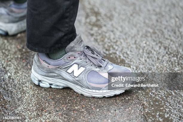 Guest wears black denim pants, gray suede / fabric and leather sneakers from New Balance, outside Rabens Saloner, during the Copenhagen Fashion Week...