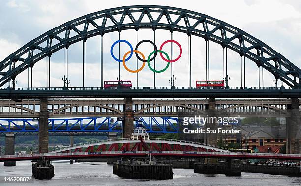 London bus crosses the Tyne Bridge as the city of Newcastle prepares for the Olympic Torch Relay by displaying the Olympic rings on the landmark on...