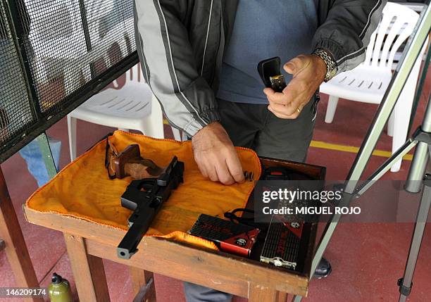 Man loads his gun at the Firing Range in Montevideo, on June 2, 2012. AFP PHOTO/Miguel ROJO