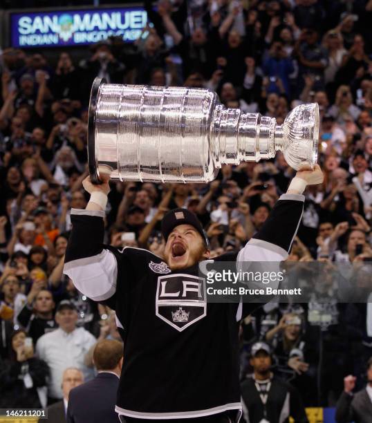 Dustin Brown of the Los Angeles Kings holds up the Stanley Cup after the Kings defeated the New Jersey Devils 6-1 to win the Stanley Cup series 4-2...