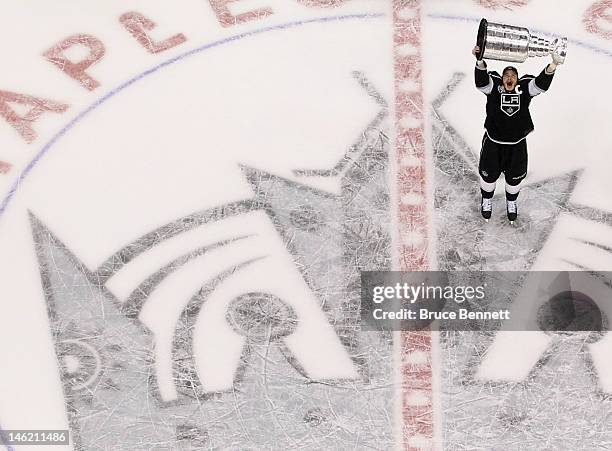 Dustin Brown of the Los Angeles Kings holds up the Stanley Cup after the Kings defeated the New Jersey Devils 6-1 to win the Stanley Cup series 4-2...