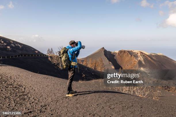 hiker taking pictures to the cumbre vieja volcano - vulkanische krater stockfoto's en -beelden