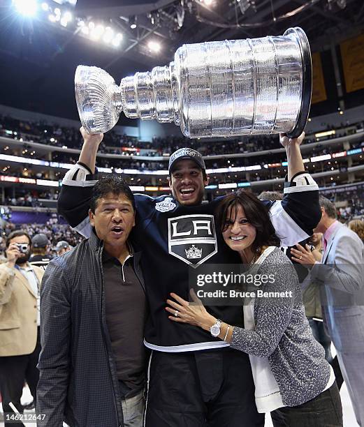 Jordan Nolan of the Los Angeles Kings holds up the Stanley Cup flanked by his parents, former NHL coach Ted Nolan and his mother Sandra, after the...