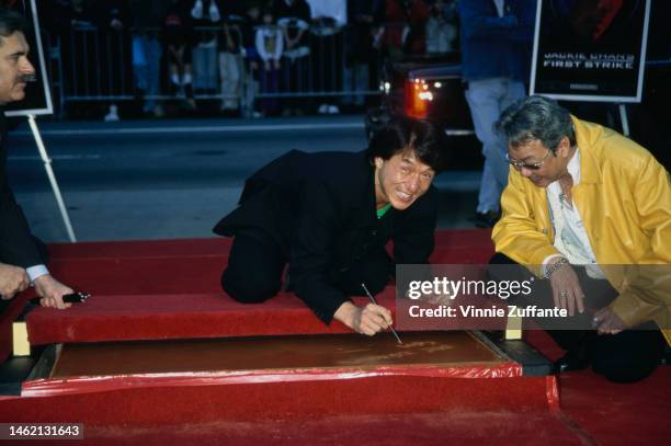 Jackie Chan embeds his hands and feet in Mann's Chinese Theatre cement. Hollywood, California, 5th January 1997.
