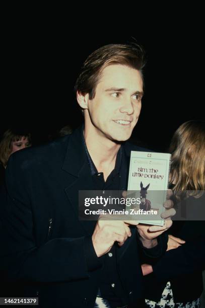 Jim Carrey holds up "Bim The Little Donkey" VHS tape at the "Cobb" Beverly Hills Premiere at the Academy Theatre in Beverly Hills, California, 29th...