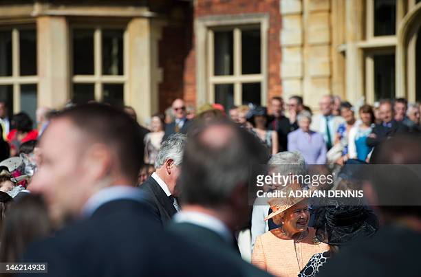 Britain's Queen Elizabeth II talks with guests during a garden party in honour of her diamond jubilee at the Queen's Sandringham Estate in Norfolk on...
